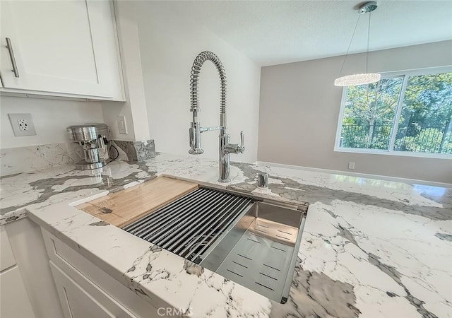 19237 Index St Unit 5, Porter Ranch, CA 91326 - kitchen with white cabinets, light stone counters, and decorative light fixtures