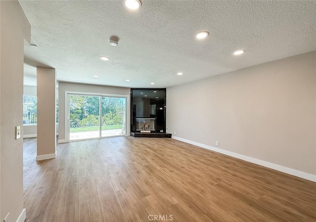 19237 Index St Unit 5, Porter Ranch, CA 91326 - unfurnished living room featuring a textured ceiling, light wood finished floors, and recessed lighting