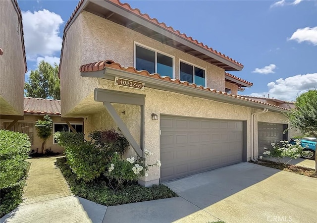 19237 Index St Unit 5, Porter Ranch, CA 91326 - view of front facade featuring a tile roof, stucco siding, and driveway