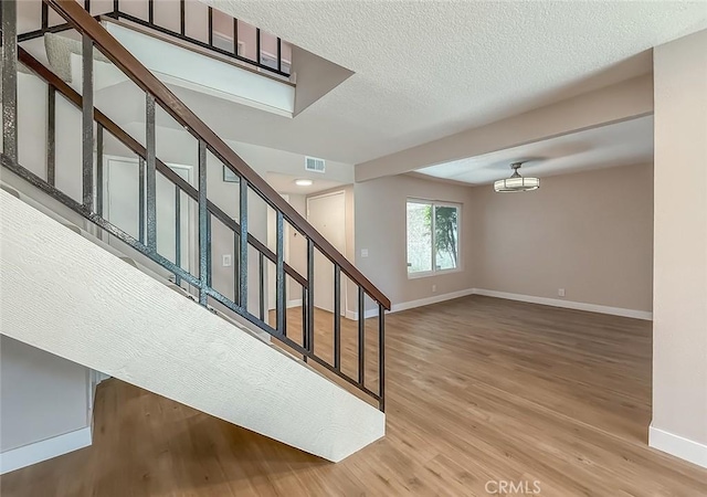 19237 Index St Unit 5, Porter Ranch, CA 91326 - staircase featuring wood finished floors and a textured ceiling