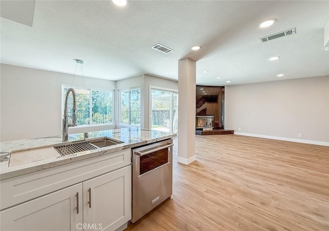 19237 Index St Unit 5, Porter Ranch, CA 91326 - kitchen with dishwasher, white cabinets, light wood-type flooring, a textured ceiling, and recessed lighting