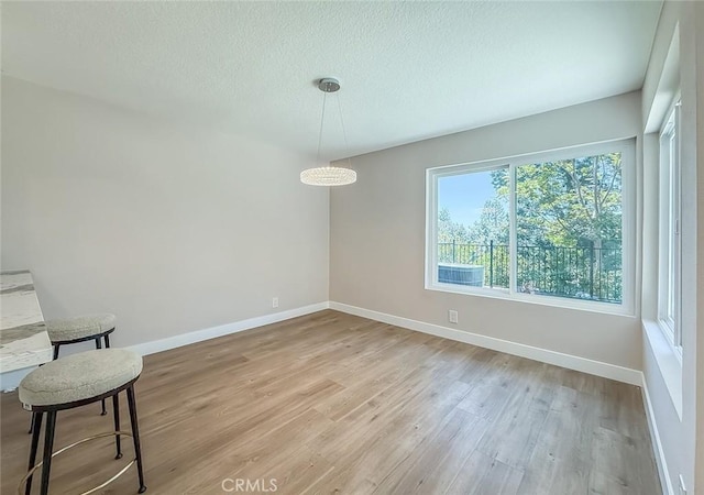 19237 Index St Unit 5, Porter Ranch, CA 91326 - unfurnished dining area with light wood-style flooring and a textured ceiling