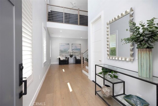 27705 Homestead Rd, Laguna Niguel, CA 92677 - corridor featuring wood finished floors, stairway, and a high ceiling