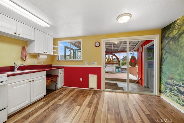 1780 Paso Robles St, Oceano, CA 93445 - kitchen with light wood finished floors, white cabinetry, and healthy amount of natural light