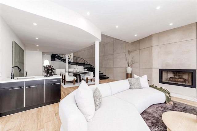 1195 La Mirada St, Laguna Beach, CA 92651 - living room with stairs, light wood-type flooring, recessed lighting, a fireplace, and tile walls