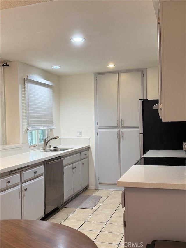 8711 Chessington Dr Unit D, Inglewood, CA 90305 - kitchen with stainless steel dishwasher, freestanding refrigerator, light countertops, recessed lighting, and light tile patterned flooring
