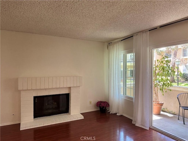 8711 Chessington Dr Unit D, Inglewood, CA 90305 - unfurnished living room featuring dark wood-style floors, a textured ceiling, and a brick fireplace