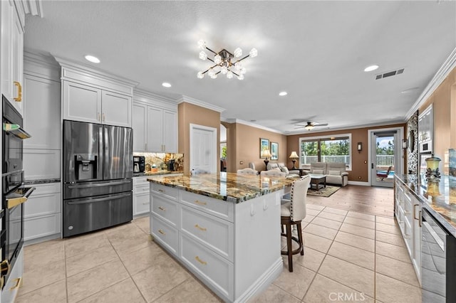 32409 Favara Dr, Temecula, CA 92592 - kitchen featuring stainless steel appliances, crown molding, light tile patterned floors, a kitchen island, and a kitchen bar