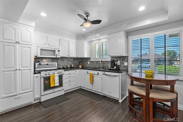 10622 Ashworth St, Bellflower, CA 90706 - kitchen with white appliances, ceiling fan, dark countertops, tasteful backsplash, and dark wood-type flooring