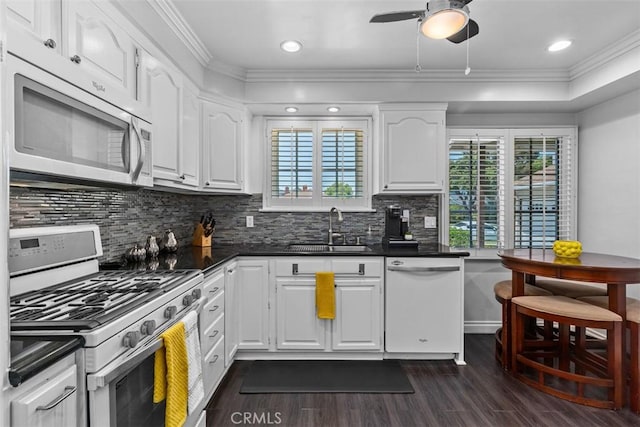 10622 Ashworth St, Bellflower, CA 90706 - kitchen featuring white appliances, dark wood-style floors, healthy amount of natural light, dark countertops, and crown molding