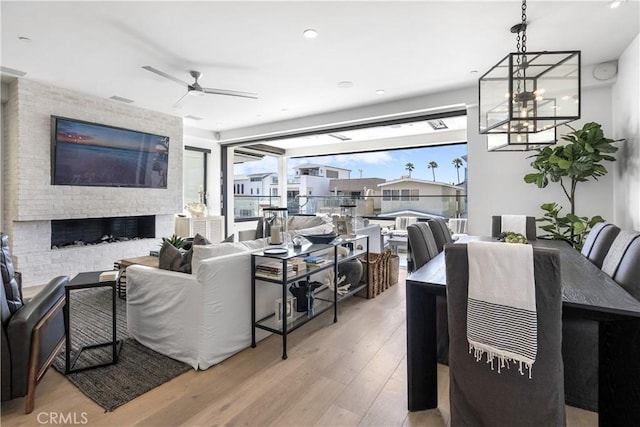 112 30th St, Newport Beach, CA 92663 - living area with wood finished floors, a chandelier, a ceiling fan, a brick fireplace, and recessed lighting