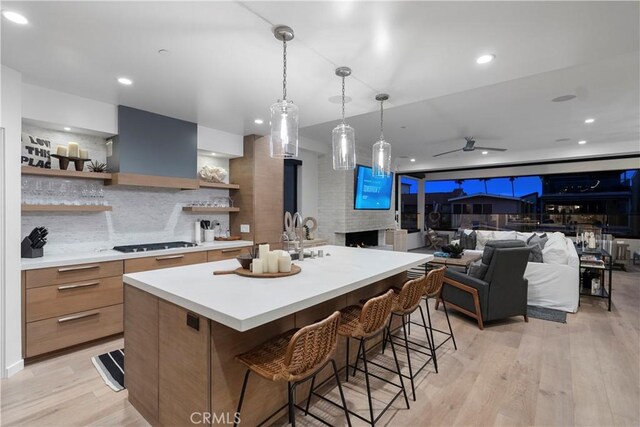 112 30th St, Newport Beach, CA 92663 - kitchen featuring open shelves, modern cabinets, a large fireplace, range hood, and stovetop