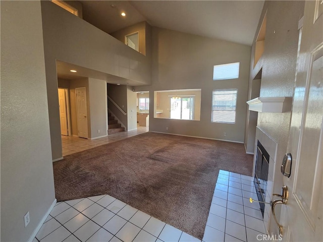 1315 Navello, El Cajon, CA 92021 - unfurnished living room with light carpet, high vaulted ceiling, light tile patterned floors, stairs, and a fireplace