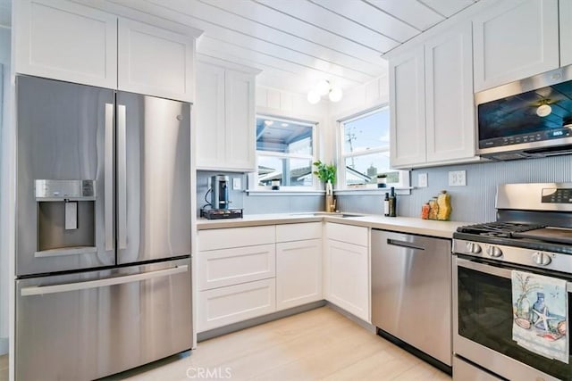 31 N 3rd St, Cayucos, CA 93430 - kitchen with stainless steel appliances, light wood-style floors, light countertops, and white cabinets