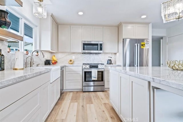 31 N 3rd St, Cayucos, CA 93430 - kitchen with appliances with stainless steel finishes, light wood-style floors, backsplash, light stone countertops, and recessed lighting