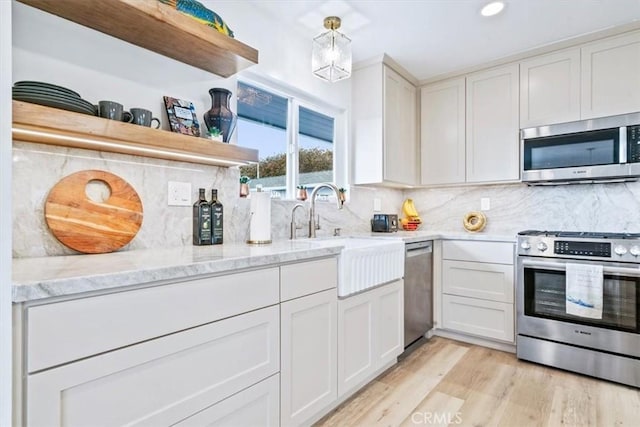 31 N 3rd St, Cayucos, CA 93430 - kitchen with stainless steel appliances, open shelves, light wood-style flooring, light stone counters, and decorative backsplash