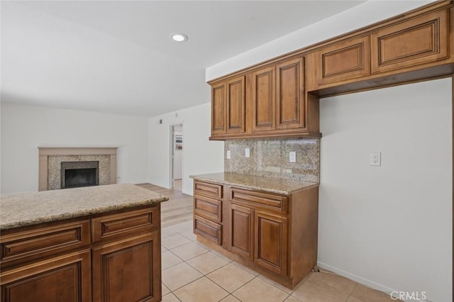 14652 Devonshire Ave, Tustin, CA 92780 - kitchen with tasteful backsplash, light tile patterned floors, brown cabinets, a fireplace, and recessed lighting