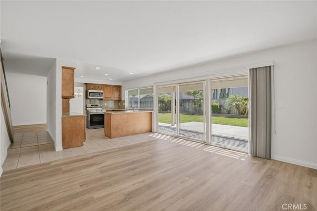 14652 Devonshire Ave, Tustin, CA 92780 - kitchen with stainless steel appliances, light wood-type flooring, brown cabinets, decorative backsplash, and recessed lighting