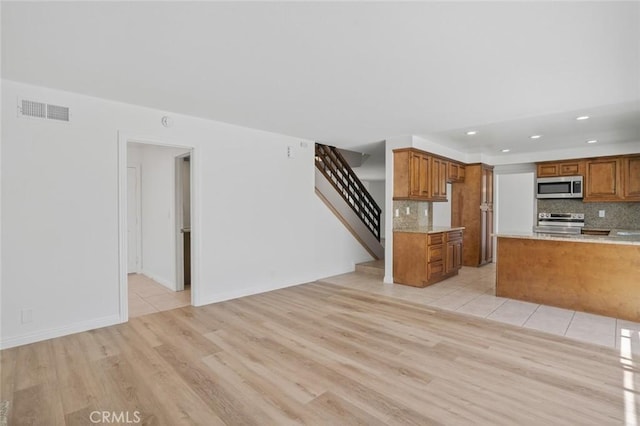 14652 Devonshire Ave, Tustin, CA 92780 - kitchen with appliances with stainless steel finishes, brown cabinetry, light wood-style floors, backsplash, and recessed lighting