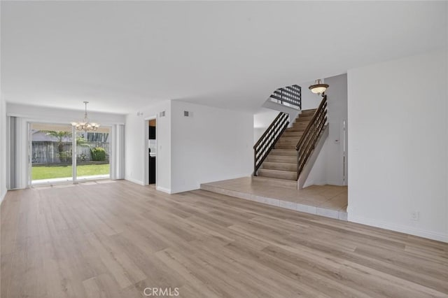 14652 Devonshire Ave, Tustin, CA 92780 - unfurnished living room with a chandelier, stairs, and light wood-style floors