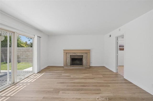 14652 Devonshire Ave, Tustin, CA 92780 - unfurnished living room with light wood-style floors and a fireplace with raised hearth