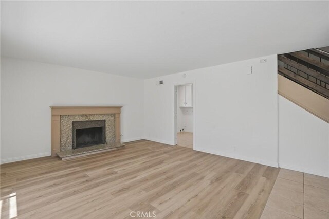 14652 Devonshire Ave, Tustin, CA 92780 - unfurnished living room with a fireplace with raised hearth and light wood-style flooring