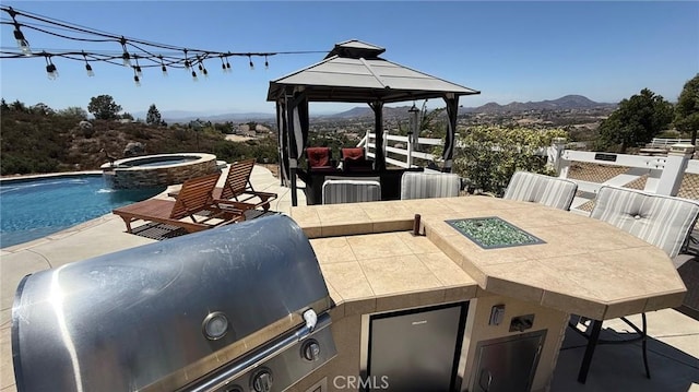 40107 Calle Breve, Temecula, CA 92592 - view of patio featuring a gazebo, a mountain view, an outdoor kitchen, and a pool with connected hot tub