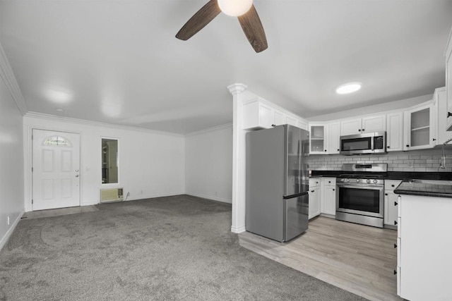 190 Avenida Descanso Unit I, Oceanside, CA 92057 - kitchen with appliances with stainless steel finishes, ceiling fan, dark countertops, glass insert cabinets, and white cabinetry