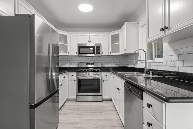 190 Avenida Descanso Unit I, Oceanside, CA 92057 - kitchen featuring appliances with stainless steel finishes, white cabinets, tasteful backsplash, and glass insert cabinets