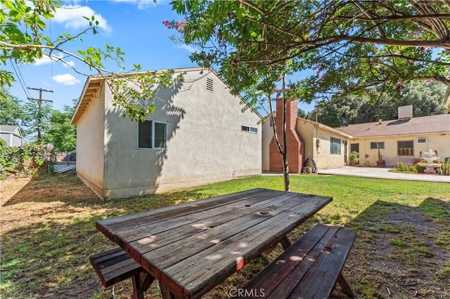 4136 Eileen St, Riverside, CA 92504 - rear view of property featuring stucco siding, a yard, and a patio