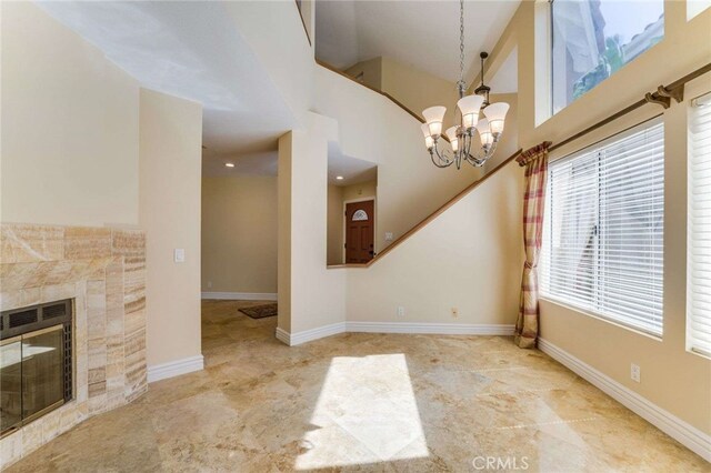 24961 Beachwalk Way, Dana Point, CA 92629 - unfurnished dining area with a chandelier, a tile fireplace, and a towering ceiling
