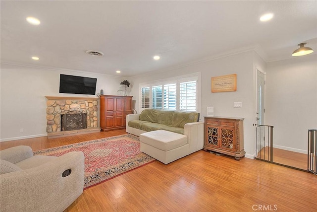 1242 2nd Pl, Calimesa, CA 92320 - living room with ornamental molding, light wood-type flooring, recessed lighting, and a stone fireplace