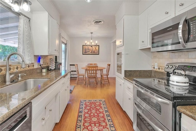 1242 2nd Pl, Calimesa, CA 92320 - kitchen featuring appliances with stainless steel finishes, a chandelier, and white cabinets