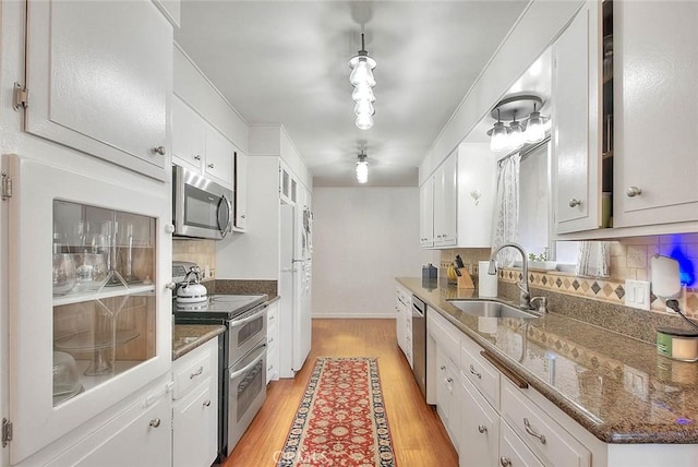 1242 2nd Pl, Calimesa, CA 92320 - kitchen with appliances with stainless steel finishes, light wood-style flooring, backsplash, and white cabinetry