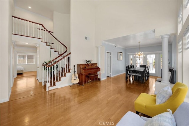 4350 Bennington Ct, Chino, CA 91710 - living room with a chandelier, a towering ceiling, decorative columns, crown molding, and stairway