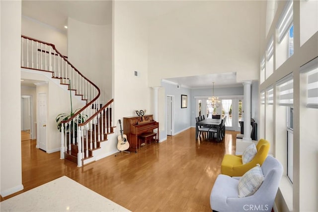 4350 Bennington Ct, Chino, CA 91710 - living area featuring a towering ceiling, wood finished floors, ornate columns, stairs, and a chandelier