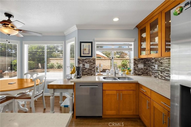 4350 Bennington Ct, Chino, CA 91710 - kitchen with appliances with stainless steel finishes, light countertops, tasteful backsplash, brown cabinetry, and healthy amount of natural light