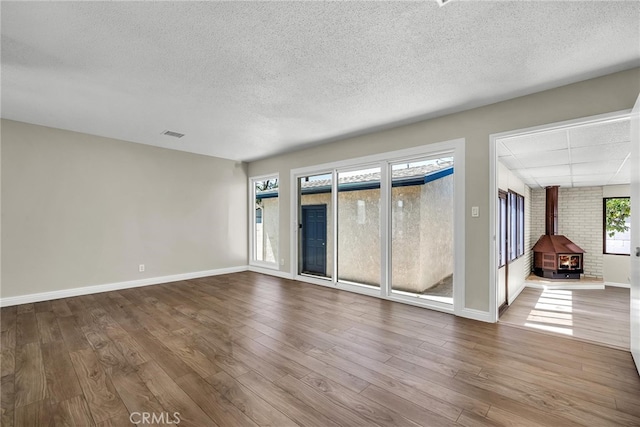 835 E 222nd St, Carson, CA 90745 - spare room with a wood stove, a textured ceiling, and wood finished floors
