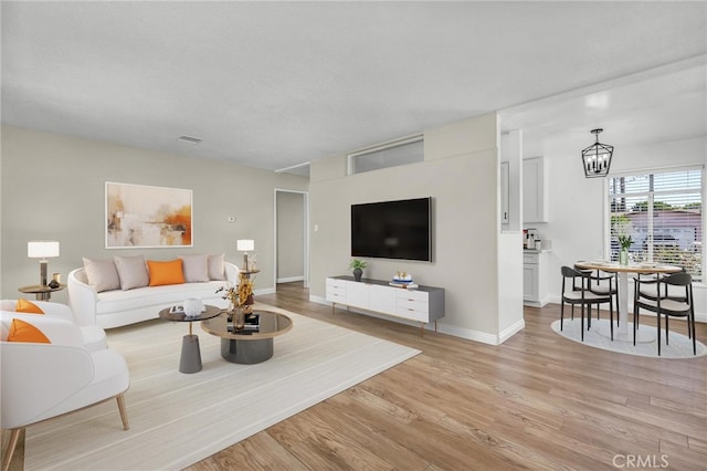 835 E 222nd St, Carson, CA 90745 - living area featuring light wood-style floors, a chandelier, and a textured ceiling