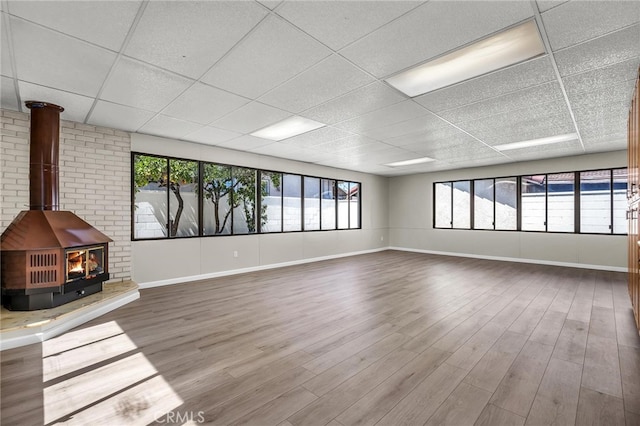 835 E 222nd St, Carson, CA 90745 - unfurnished living room with a drop ceiling, a wood stove, and wood finished floors