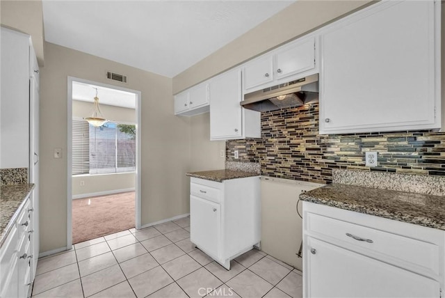 1407 Opal St, Corona, CA 92882 - kitchen with under cabinet range hood, white cabinets, dark stone countertops, decorative backsplash, and light tile patterned flooring