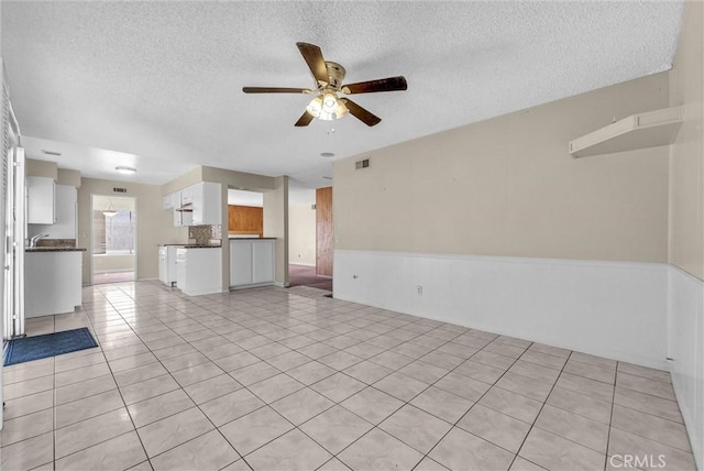 1407 Opal St, Corona, CA 92882 - unfurnished living room with a textured ceiling, a ceiling fan, and light tile patterned flooring