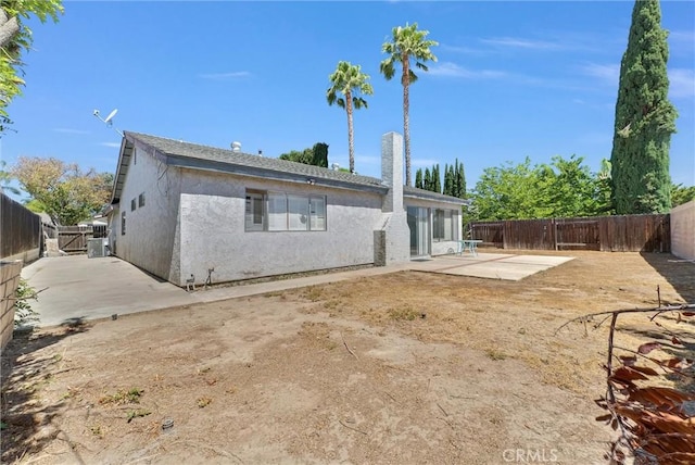 1407 Opal St, Corona, CA 92882 - rear view of property featuring a patio area, a fenced backyard, stucco siding, and a chimney