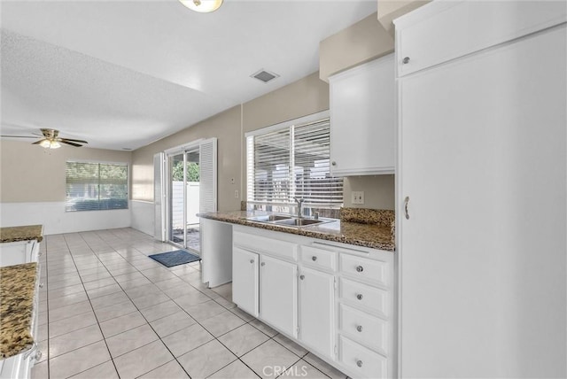 1407 Opal St, Corona, CA 92882 - kitchen featuring white cabinetry, a ceiling fan, light tile patterned floors, and dark stone counters