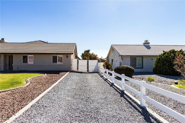 7434 Paisley Ave, Hesperia, CA 92345 - view of side of property with a tiled roof, stucco siding, and a chimney