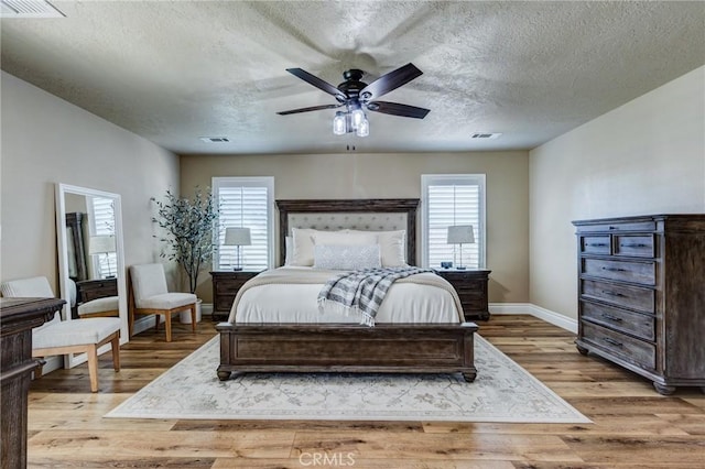 7434 Paisley Ave, Hesperia, CA 92345 - bedroom with multiple windows, wood finished floors, a textured ceiling, and a ceiling fan