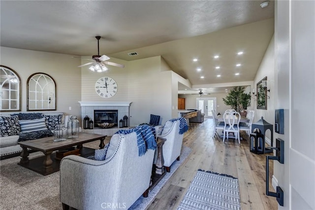 7434 Paisley Ave, Hesperia, CA 92345 - living room with a ceiling fan, light wood-type flooring, and a tiled fireplace