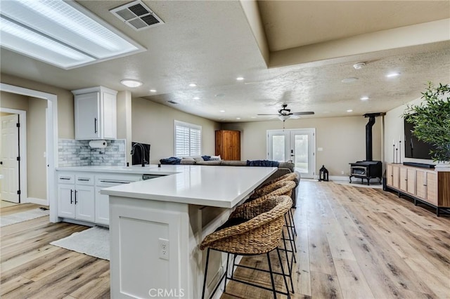 7434 Paisley Ave, Hesperia, CA 92345 - kitchen featuring open floor plan, a wood stove, light countertops, a peninsula, and a breakfast bar area