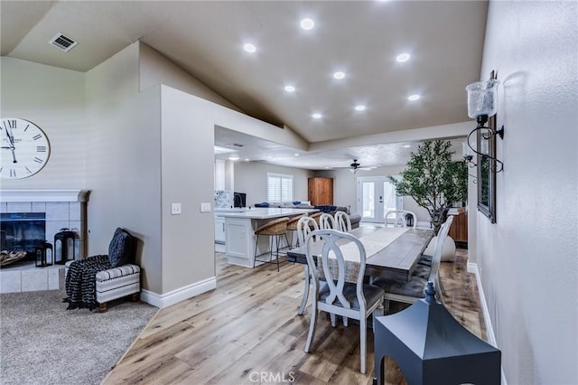 7434 Paisley Ave, Hesperia, CA 92345 - dining area featuring light wood finished floors, ceiling fan, lofted ceiling, a tile fireplace, and recessed lighting