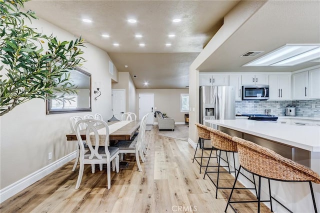 7434 Paisley Ave, Hesperia, CA 92345 - dining area featuring light wood-style floors, recessed lighting, and vaulted ceiling